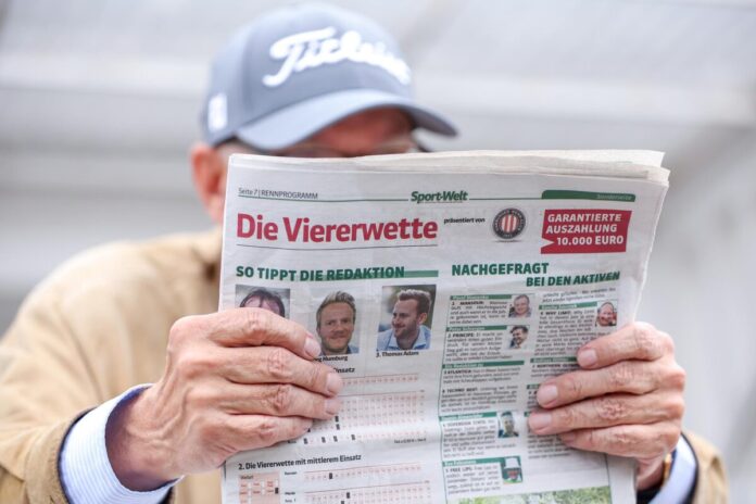 Rennbahnbesucher liest die Sportwelt mit der Viererwette